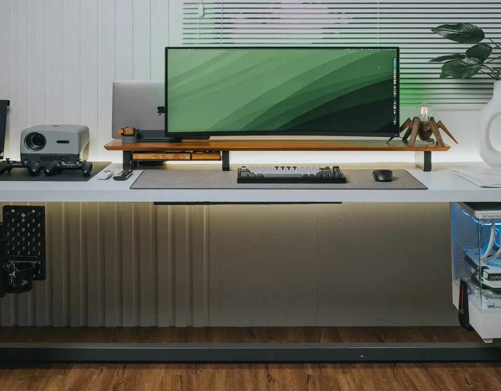	A wooden monitor riser elevating a monitor on a small home office desk