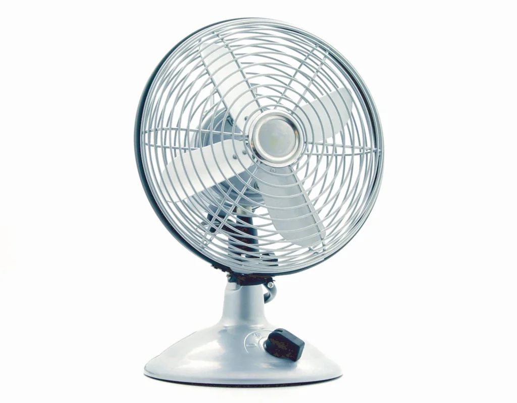 Compact personal desk fan providing focused airflow in a small home office