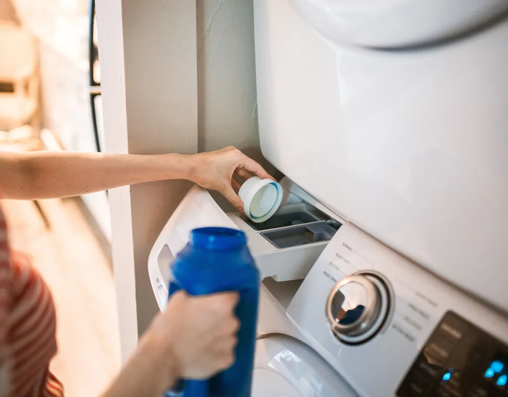 Compact detergent dispenser and organized laundry supplies on a small shelf