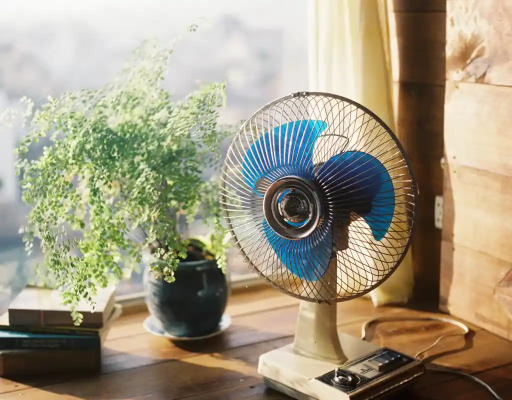 Small oscillating desk fan providing airflow across a home office workspace for small home office