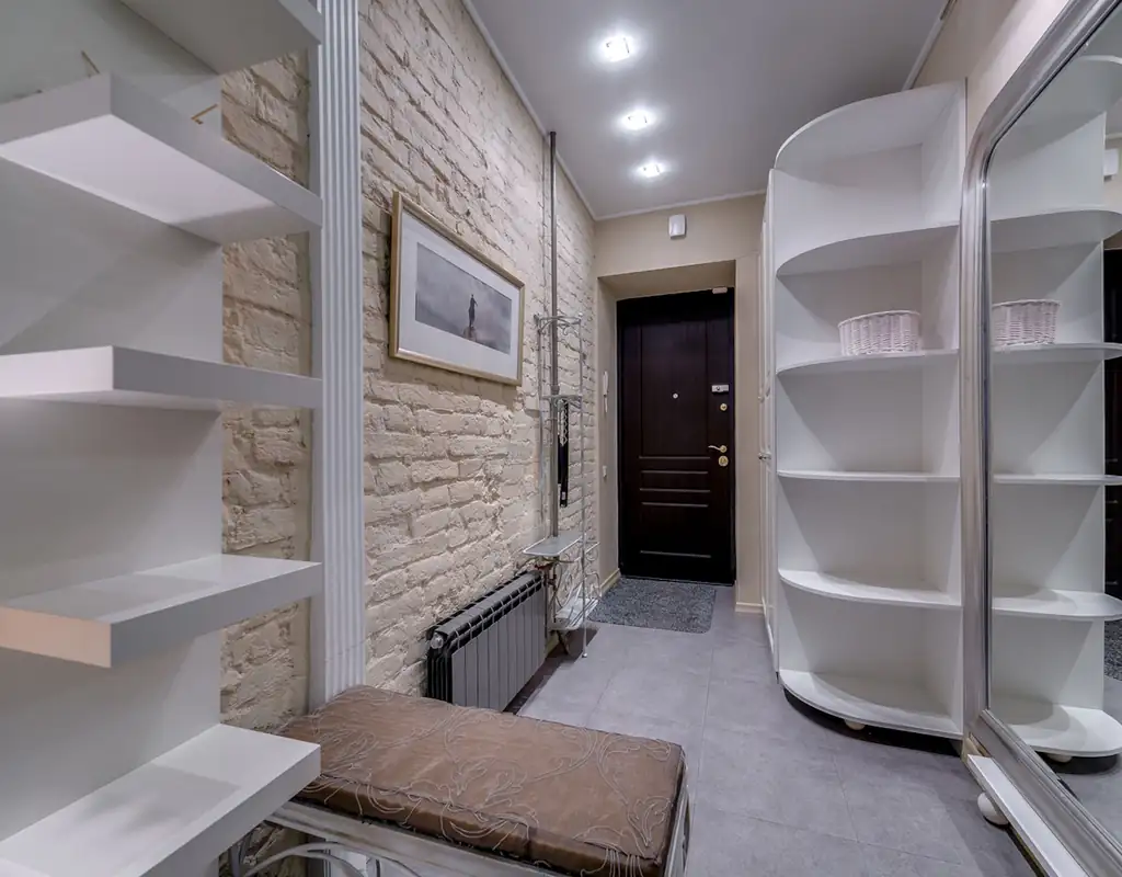 Small living room with wall-mounted shelves used for vertical storage